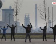 图为耗资13亿建成的邯郸武安市体育馆外，本地的不少中年妇女，每天会在固定时间来到这里：她们背对体育馆，面向文安钢铁厂，跳起了广场舞。邯郸武安市区有十几个钢铁厂、电厂、焦化厂包围，不管刮什么风，城区污染都很严重。视觉中国